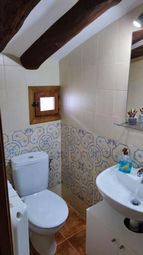 y baño con aseo y lavamanos. en Casa rural completa LA CRIVA 11pers, en Crivillén