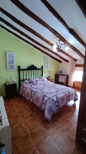 1 dormitorio con 1 cama con colcha púrpura en Casa rural completa LA CRIVA 11pers, en Crivillén