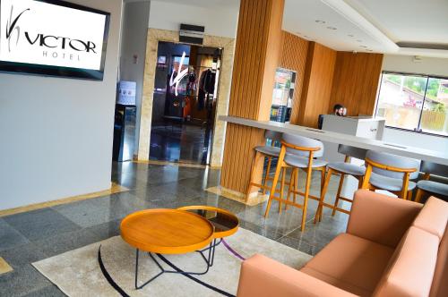 a lobby with a table and chairs in a store at Hotel Victor in Patos de Minas
