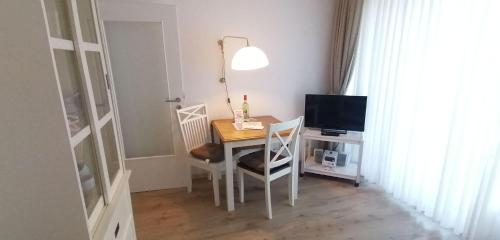 mesa de comedor con ordenador y TV en Sylter-Besserburg-App-13, en Westerland