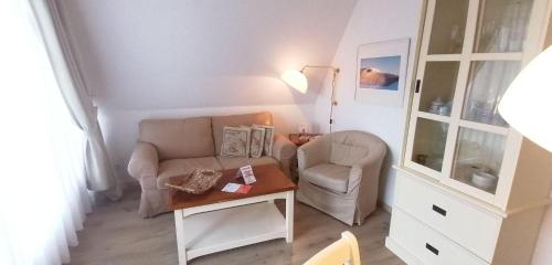 sala de estar con sofá, silla y mesa en Sylter-Besserburg-App-13, en Westerland
