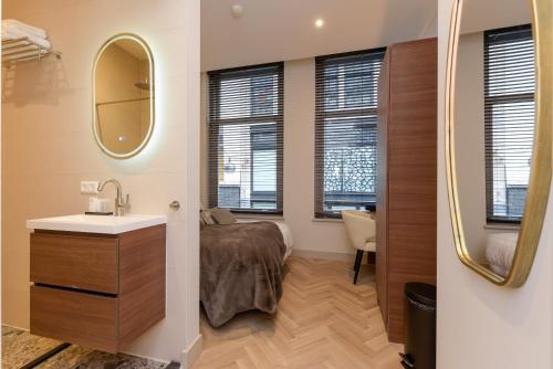 een badkamer met een wastafel en een spiegel bij Novallure City Centre in Den Haag