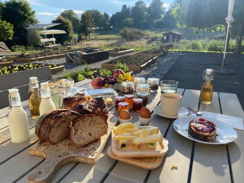 Puidoux的住宿－Le Hameau du Montchervet，一张桌子上放着面包、鸡蛋和奶酪
