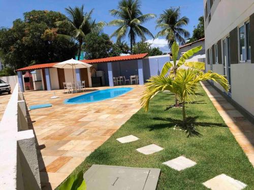 un patio trasero de una casa con piscina en Suite 100m da praia de Porto de Galinhas, en Porto de Galinhas