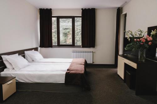 a bedroom with a large bed and a window at Borovets Green Hotel in Borovets