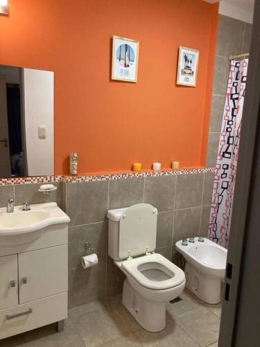 La salle de bains orange est pourvue de toilettes et d'un lavabo. dans l'établissement Hermoso dpto. en Alta Córdoba, à Córdoba