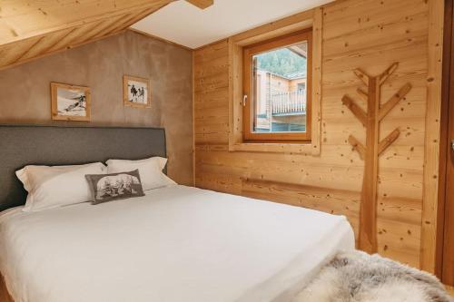 1 dormitorio con cama blanca y ventana en Chalet Isabella : cozy & comfy in central Chamonix, en Chamonix-Mont-Blanc