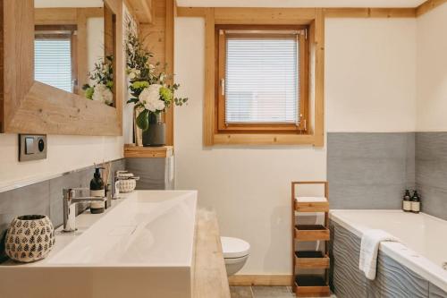 une salle de bain avec une baignoire, un lavabo et des toilettes dans l'établissement Chalet Isabella by Brennus Chamonix, à Chamonix-Mont-Blanc