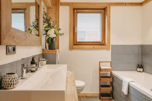 a bathroom with a tub and a sink and a toilet at Chalet Isabella : cozy & comfy in central Chamonix in Chamonix