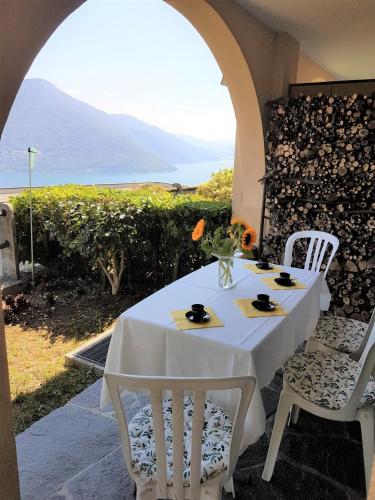 una mesa blanca con sillas y vistas al océano en "Vista Bellissima", en Brissago