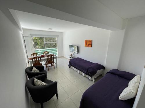 1 dormitorio con 1 cama, mesa y sillas en Hermoso Departamento céntrico a 50mts del mar en Puerto Madryn