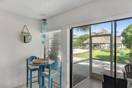 a dining room with a table and chairs and a sliding glass door at Ohana Keys in Key Largo