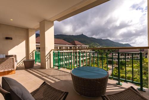 a balcony with a table and chairs and a view at Savoy Seychelles Resort & Spa in Beau Vallon