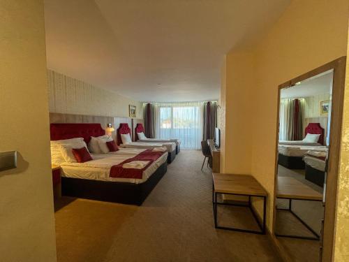 a hotel room with two beds and a mirror at Katalina SPA Resort in Tsigov Chark