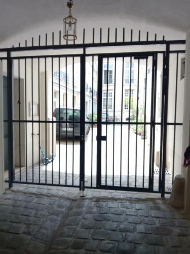 une porte en fer avec vue sur la rue dans l'établissement 85 M2 Montorgueil Suite WiFi Tout Confort Idéal, à Paris
