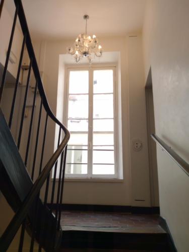 un escalier avec un lustre devant une fenêtre dans l'établissement 85 M2 Montorgueil Suite WiFi Tout Confort Idéal, à Paris