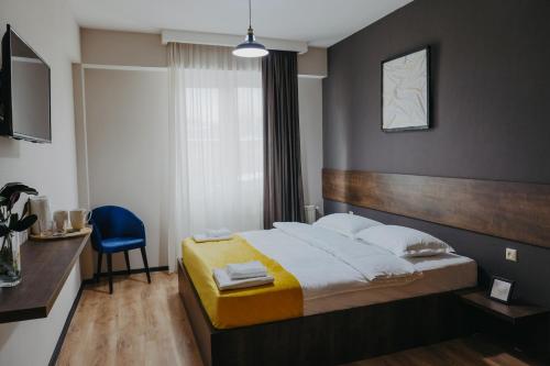 a bedroom with a bed and a blue chair at GABATA INN in Bakuriani