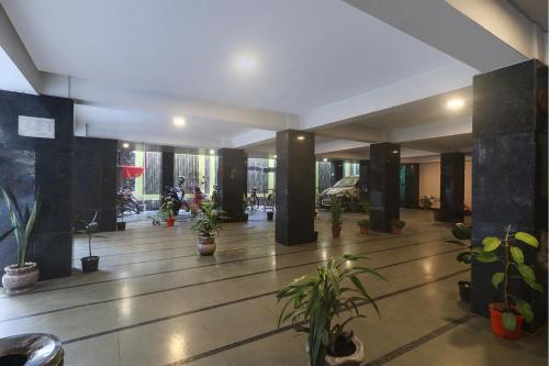 a lobby with potted plants in a building at FabExpress Ganpati 2 - Nr Siliguri Junction in Siliguri