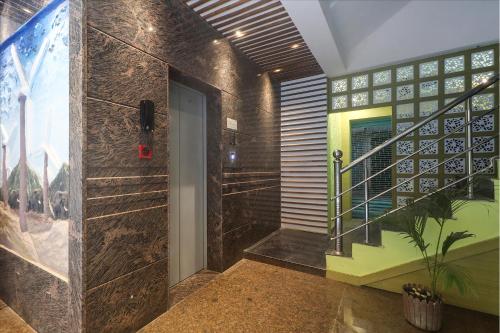 a hallway with a door and a staircase in a building at FabExpress Ganpati 2 - Nr Siliguri Junction in Siliguri