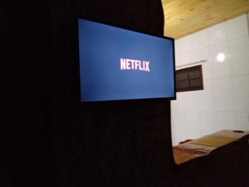 een bord met Netflix op een muur in een kamer bij Recanto KAIRÓS in Visconde De Maua