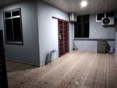 ein leeres Zimmer mit Holzboden und Tür in der Unterkunft D'illahs Homestay in Alor Setar