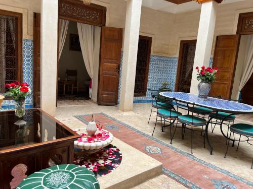 a patio with a table and chairs in a room at Riad Dar Les Freres in Marrakech
