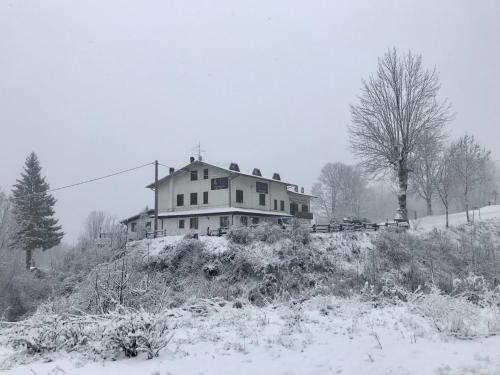 dom na szczycie wzgórza w śniegu w obiekcie La Buca delle Fate w mieście Pievepelago