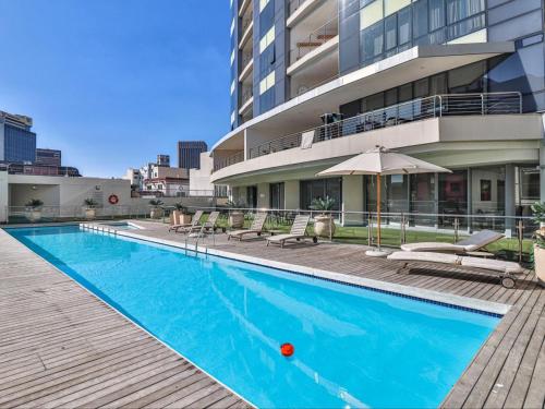 a large swimming pool in front of a building at Mandela Place Apartment in Cape Town