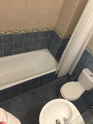 a bathroom with a toilet and a tub and a sink at Cosy 2 bedroom apartment in Paphos City