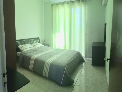 a bedroom with a large bed and a window at Cosy 2 bedroom apartment in Paphos