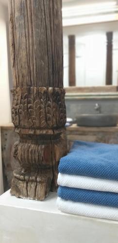 a stack of towels sitting next to a wooden pole at El Violin Experiencia Adults only in Melegis