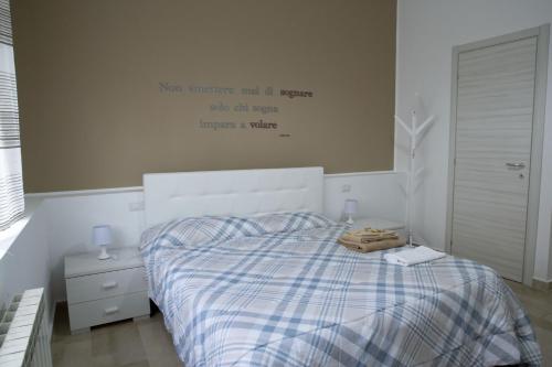ein Schlafzimmer mit einem Bett mit einem Schild an der Wand in der Unterkunft A Quattro Passi in San Cataldo