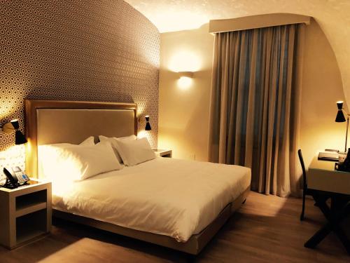 a hotel room with a bed and a desk and a bed sidx sidx at Caruso Place Boutique & Wellness Suites in Naples