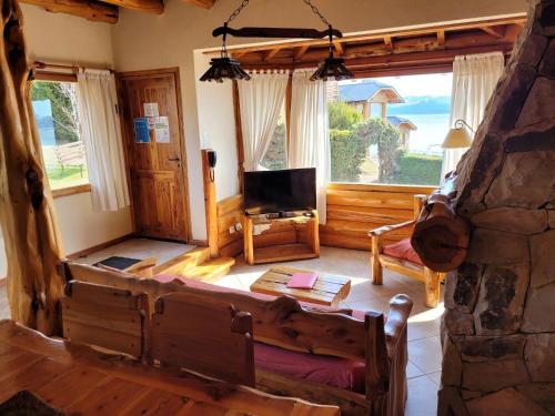a living room with a couch and a tv in a house at Cabañas Chesa Engadina in San Carlos de Bariloche