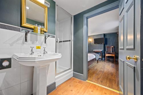 a bathroom with a white sink and a bedroom at The Fat Badger York in York