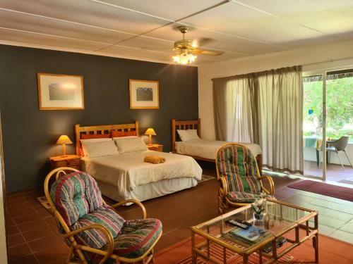 1 dormitorio con 2 camas, mesa y sillas en Otters' Haunt Eco Retreat, en Parys