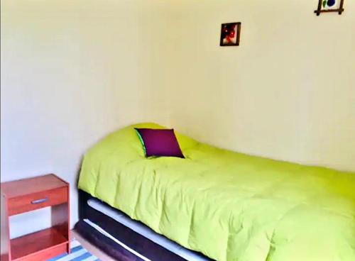 sypialnia z zielonym łóżkiem i stolikiem nocnym w obiekcie Pelluco w mieście Puerto Montt