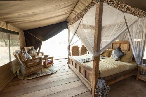 Sinoni的住宿－Africa Safari South Serengeti Ndutu Ngorongoro，一间帐篷内带天蓬床的卧室