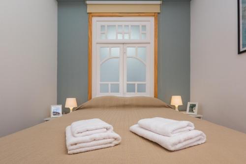 a bedroom with a bed with two towels on it at Fontainhas River Residence in Porto
