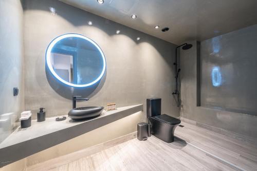 W łazience znajduje się niebieskie lustro i toaleta. w obiekcie Snowglory Boutique Hotel w mieście Arachova
