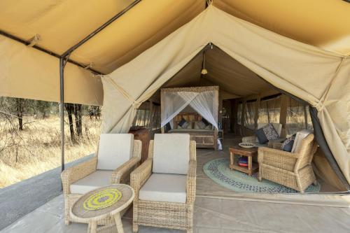a tent with two chairs and a table in it at Africa Safari South Serengeti Ndutu Ngorongoro in Sinoni