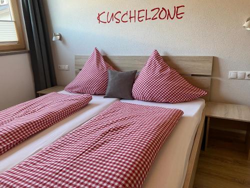 two beds in a room with red and white pillows at Ferienwohnung Mario in Hippach