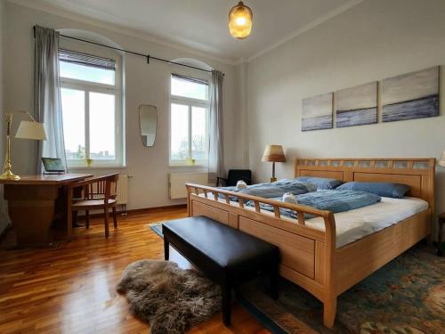 德勒斯登的住宿－4 Raum Wohnung mit Balkon auf 120sqm in Top Lage，一间卧室配有一张大床、一张桌子和一张桌子