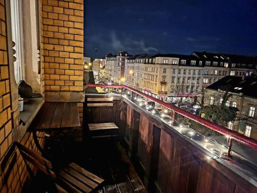 un balcón con un banco y una ciudad por la noche en 4 Raum Wohnung mit Balkon auf 120sqm in Top Lage, en Dresden