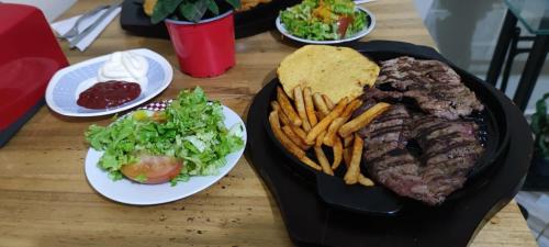 een tafel met een bord biefstuk en frietjes bij Hospedaje Campestre El Rancho de Jero in Jardin