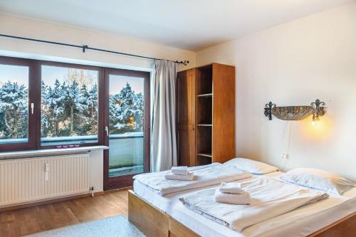 - une chambre avec un grand lit et une grande fenêtre dans l'établissement Haus Excelsior Top 3, à Seefeld in Tirol