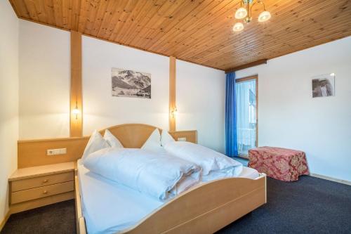 索爾達的住宿－Haus Lena，一间卧室设有一张带木制天花板的大床