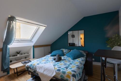 une chambre avec un lit avec un mur bleu dans l'établissement L'appart K-BANE- Wifi Fibre- Checkin auto- 2 pers, au Mans