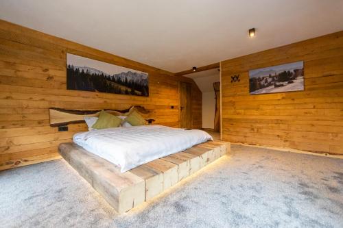 1 dormitorio con 1 cama en una pared de madera en Moșia Sofiei, en Moieciu de Sus