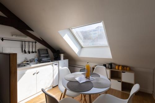 une cuisine avec une table et des chaises et une fenêtre dans l'établissement L'appart K-shmire- Cosy et spacieux, 4 pers, au Mans